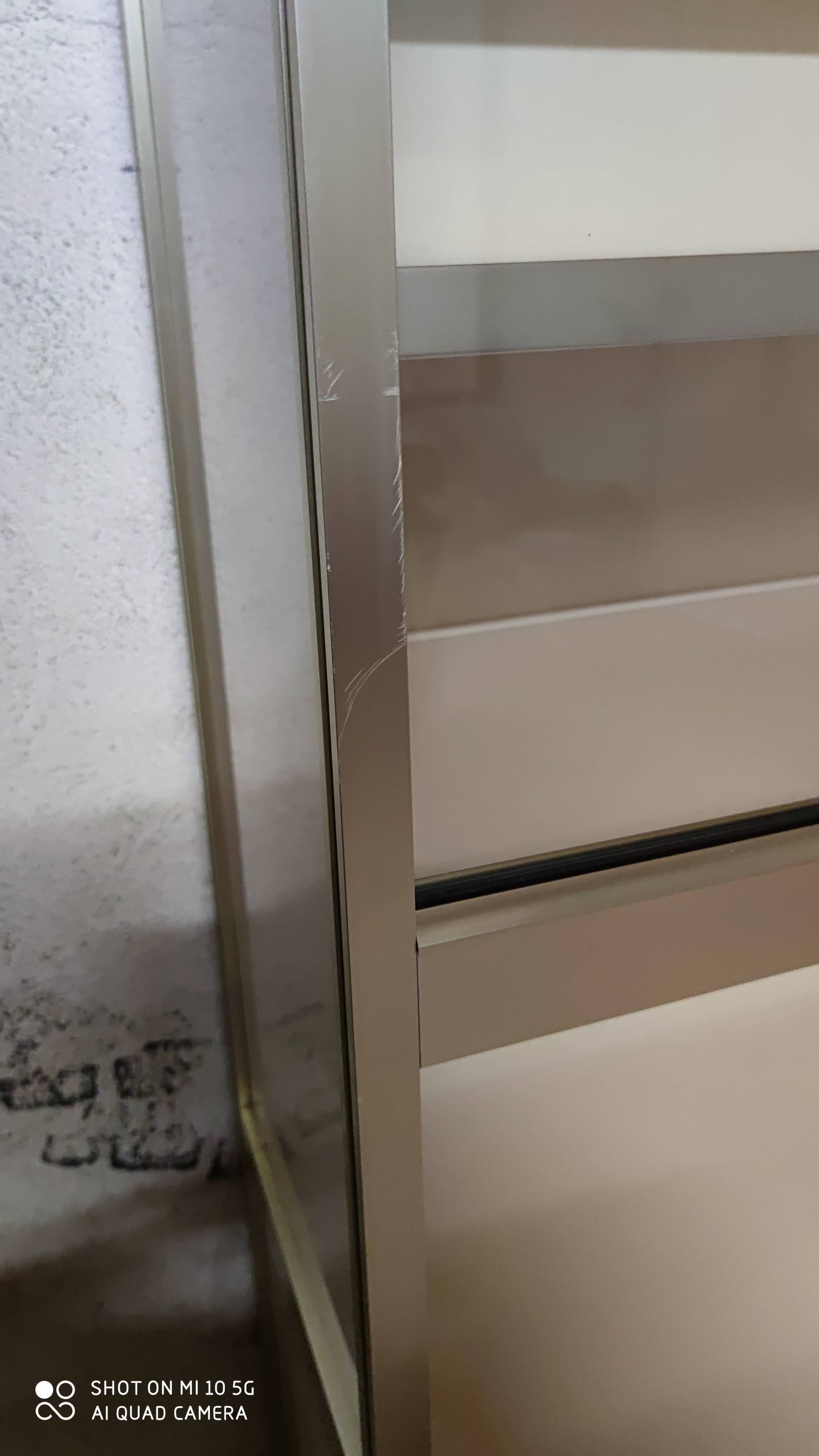 Ivory-colored and matte gold anodized aluminum display bookcase