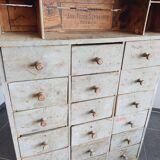 Craft cabinet with drawers with a very old tobacco advertisement in the background
