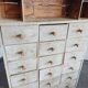 Craft cabinet with drawers with a very old tobacco advertisement in the background