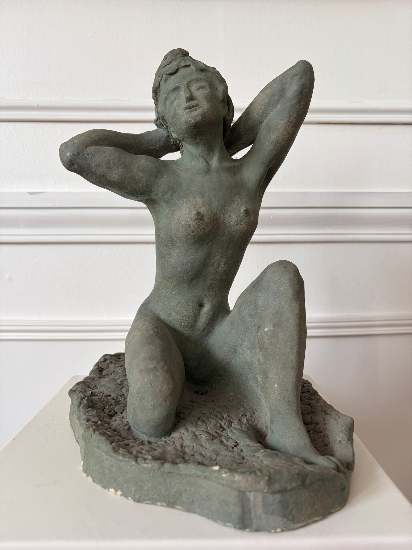 Sculpture of a naked woman titled "Youth" in terracotta.