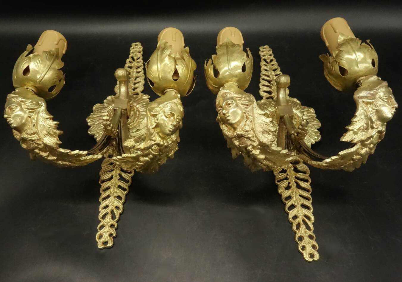 Pair of wall sconces with mask motifs in Empire style from the early 1900s - gilded bronze.