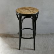 Curved wooden bar stool with a caned seat.