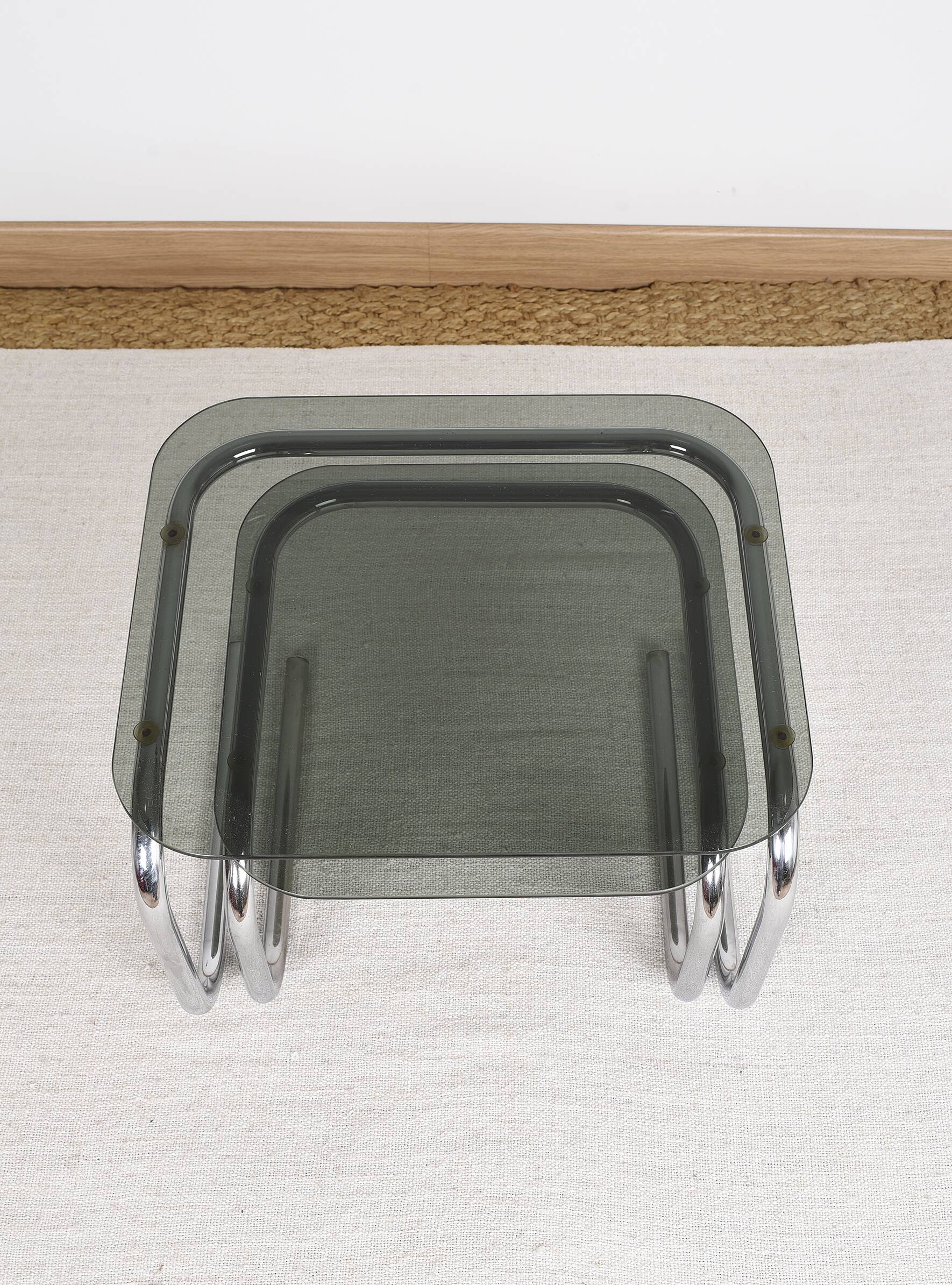 Pair of nesting tables in smoked glass and chrome legs.