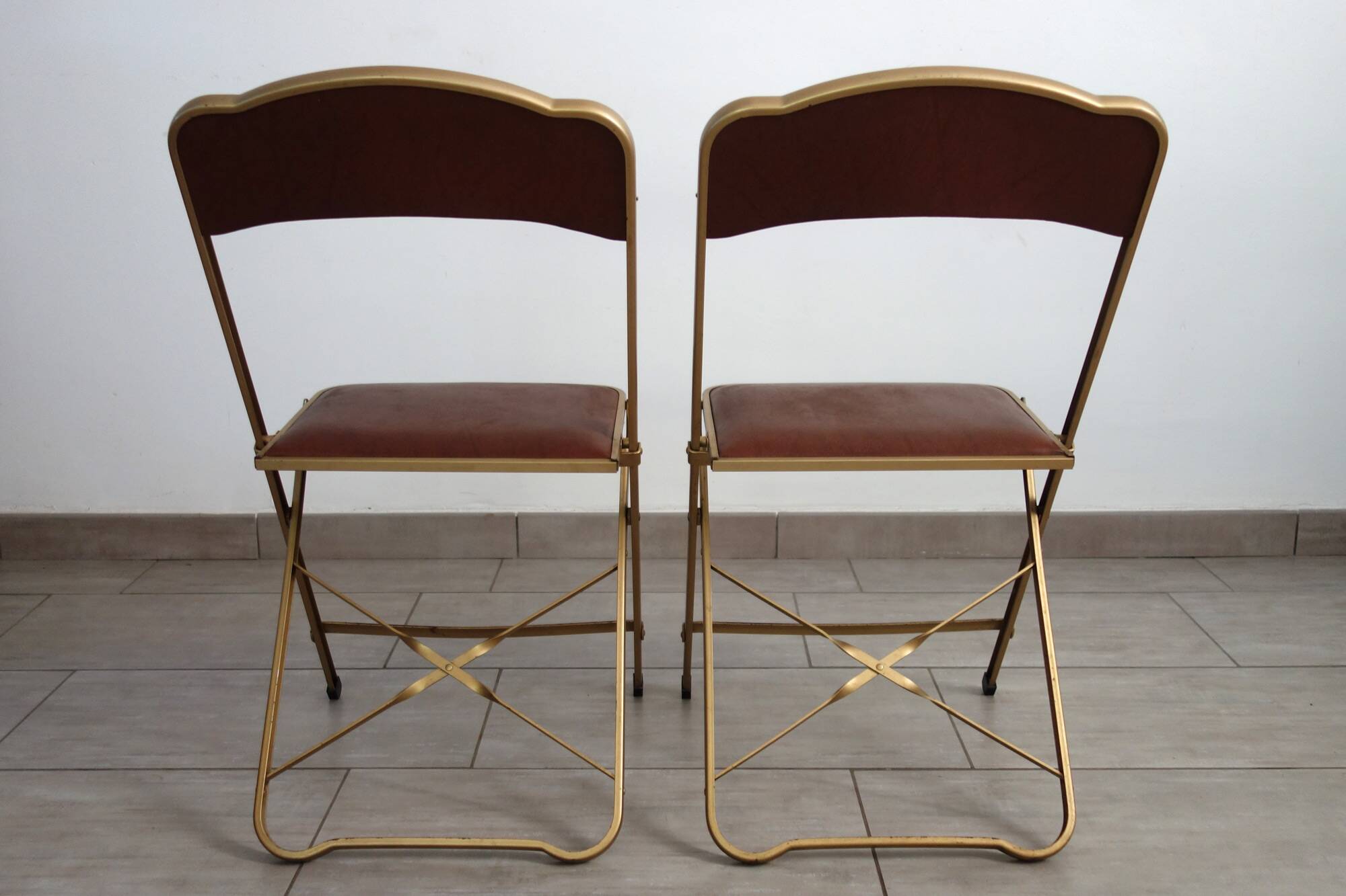 2 golden metal chairs with faux leather in the 60s/70s Opera style.