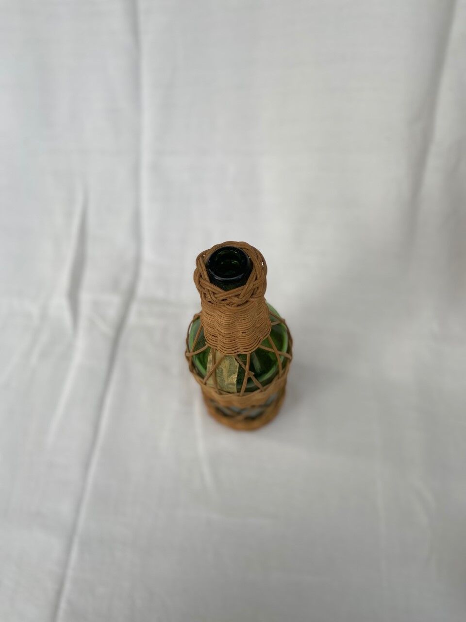 Green bottle with wicker decoration