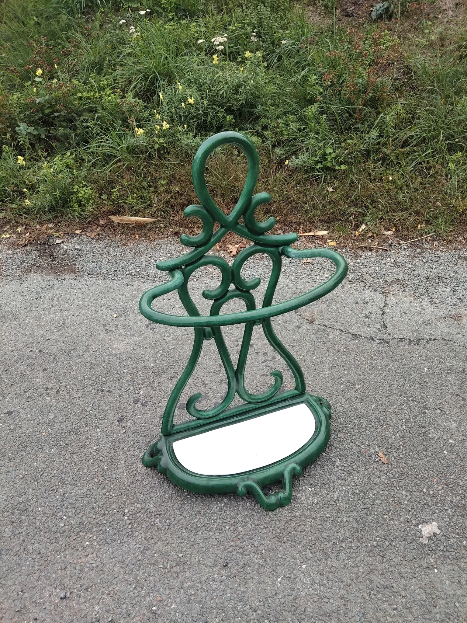 Bottle green enamelled cast iron umbrella stand with a swirl design.