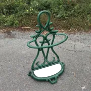 Bottle green enamelled cast iron umbrella stand with a swirl design.