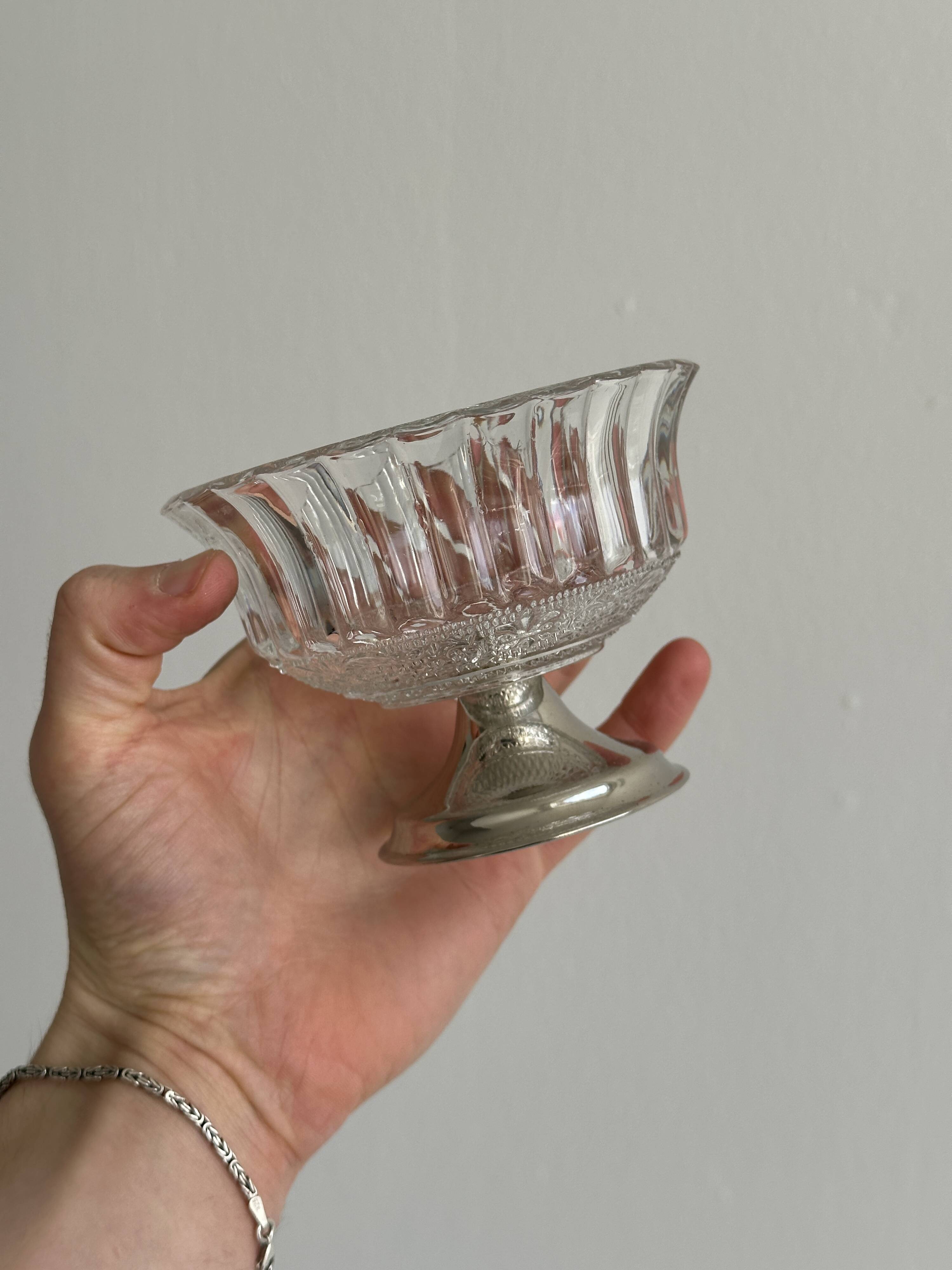 Thick glass bowl on a metal stand.