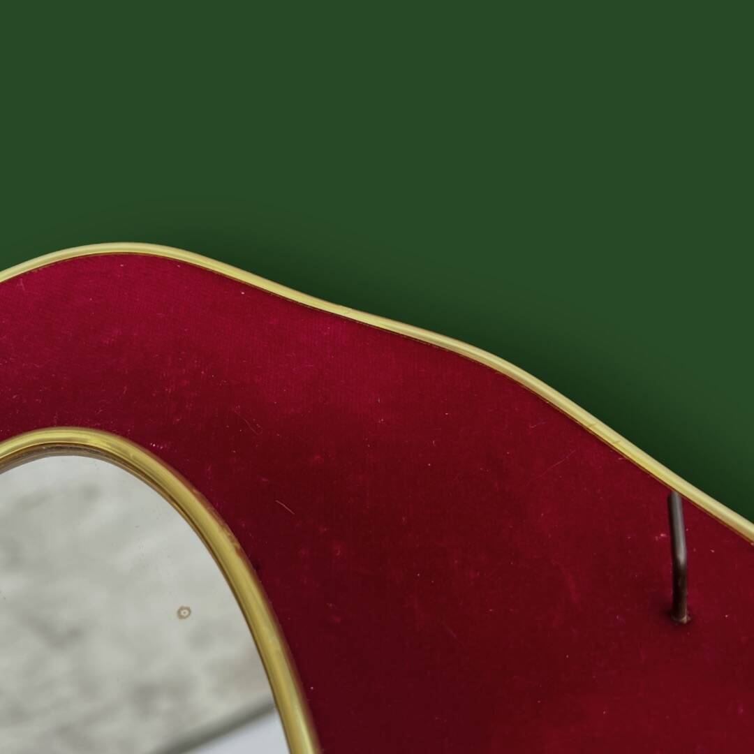 Oval wall mirror in burgundy velvet and brass – 1950s–1960s
