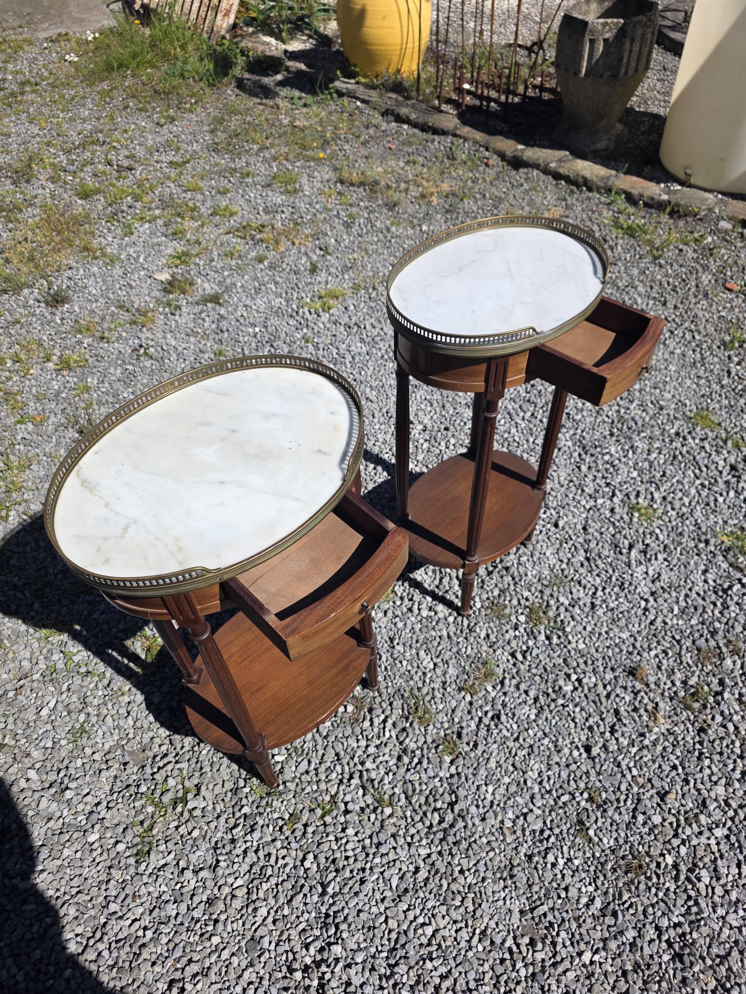 Pair of Louis XVI style bedside tables in mahogany, with marble tops.