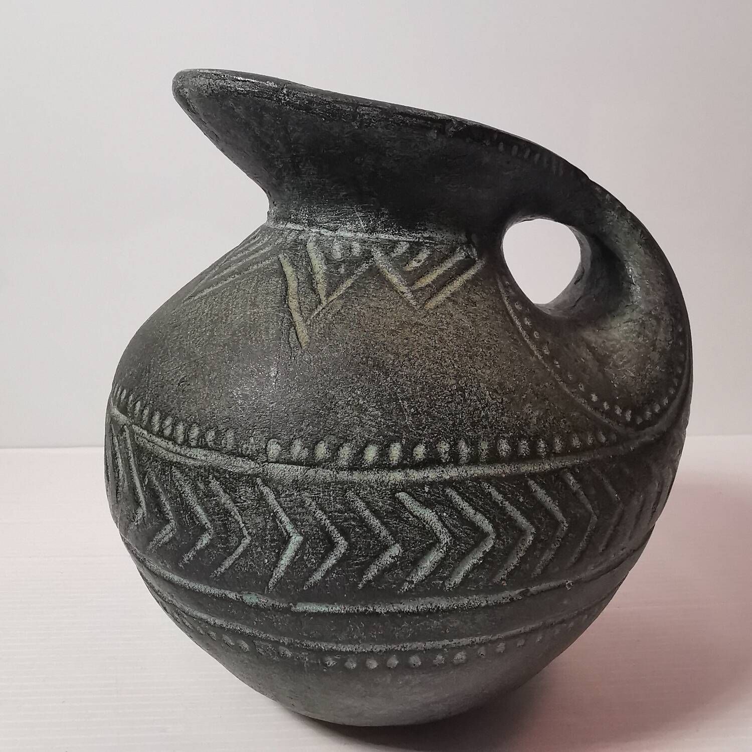 Vintage native american jug pot with geometric patterns in green / gray tones