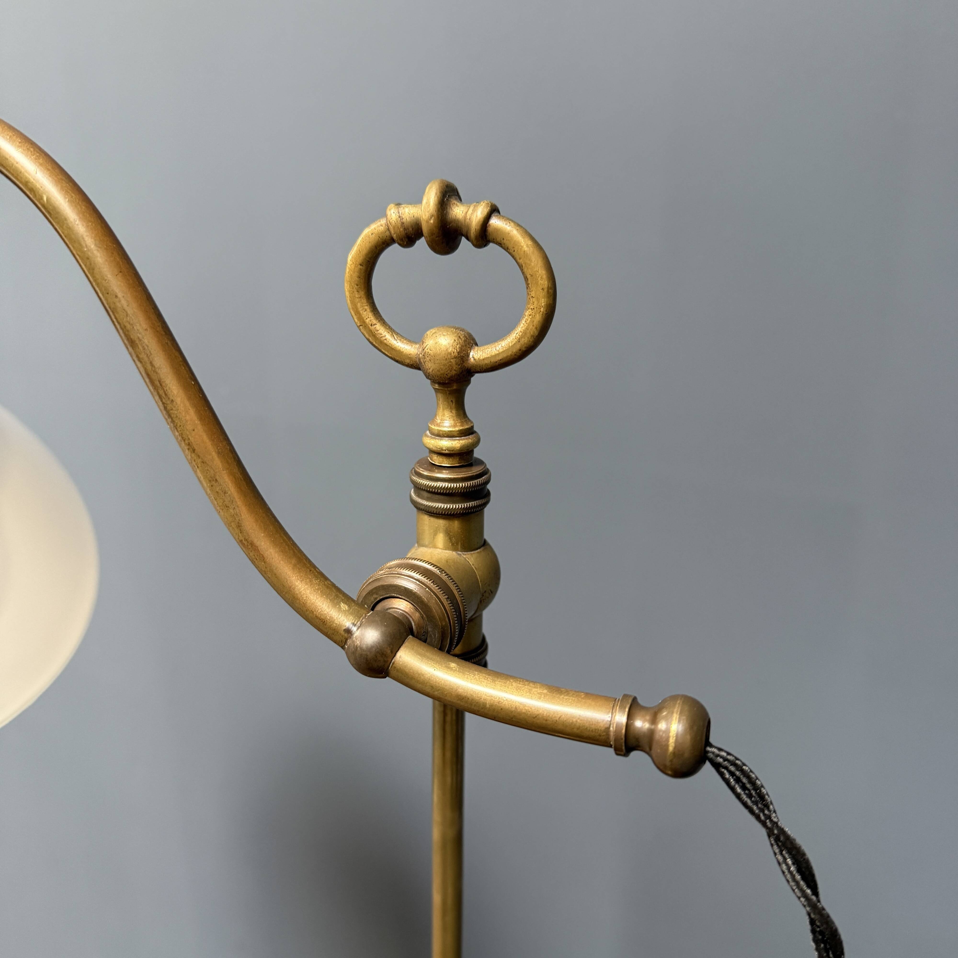 Adjustable brass table lamp with opaline glass shade