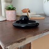 Vintage black ceramic candle holder on a bowl