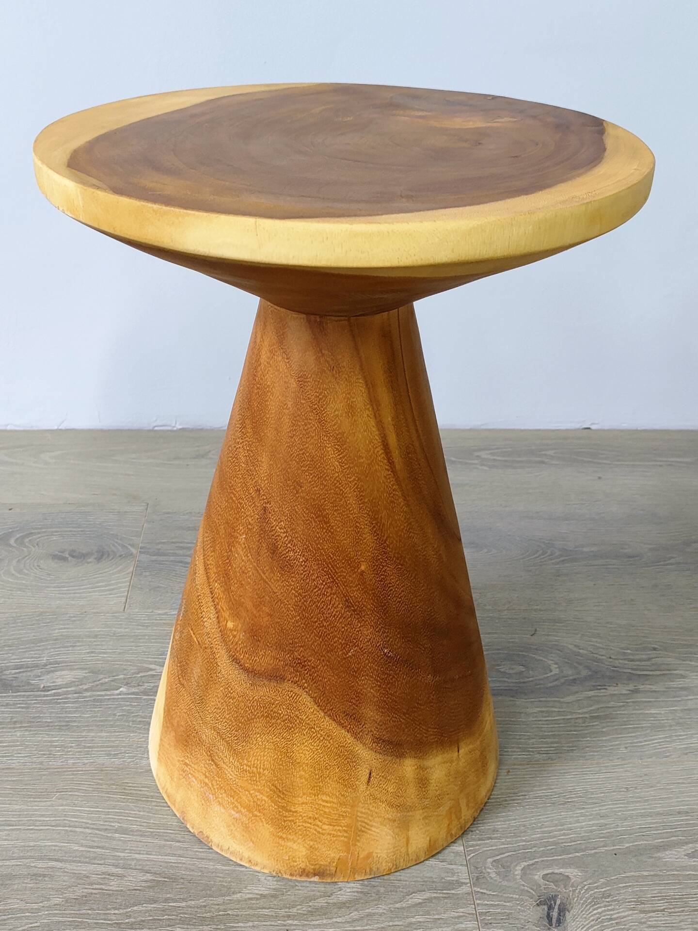 Minimalist side table in solid suar wood with conical legs.