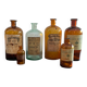 Lot d'anciens flacons de parfumeurs en verre avec étiquettes d'origine