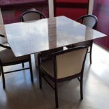 Square table in burgundy marble, its 4 matching chairs in white fabric and its buffet