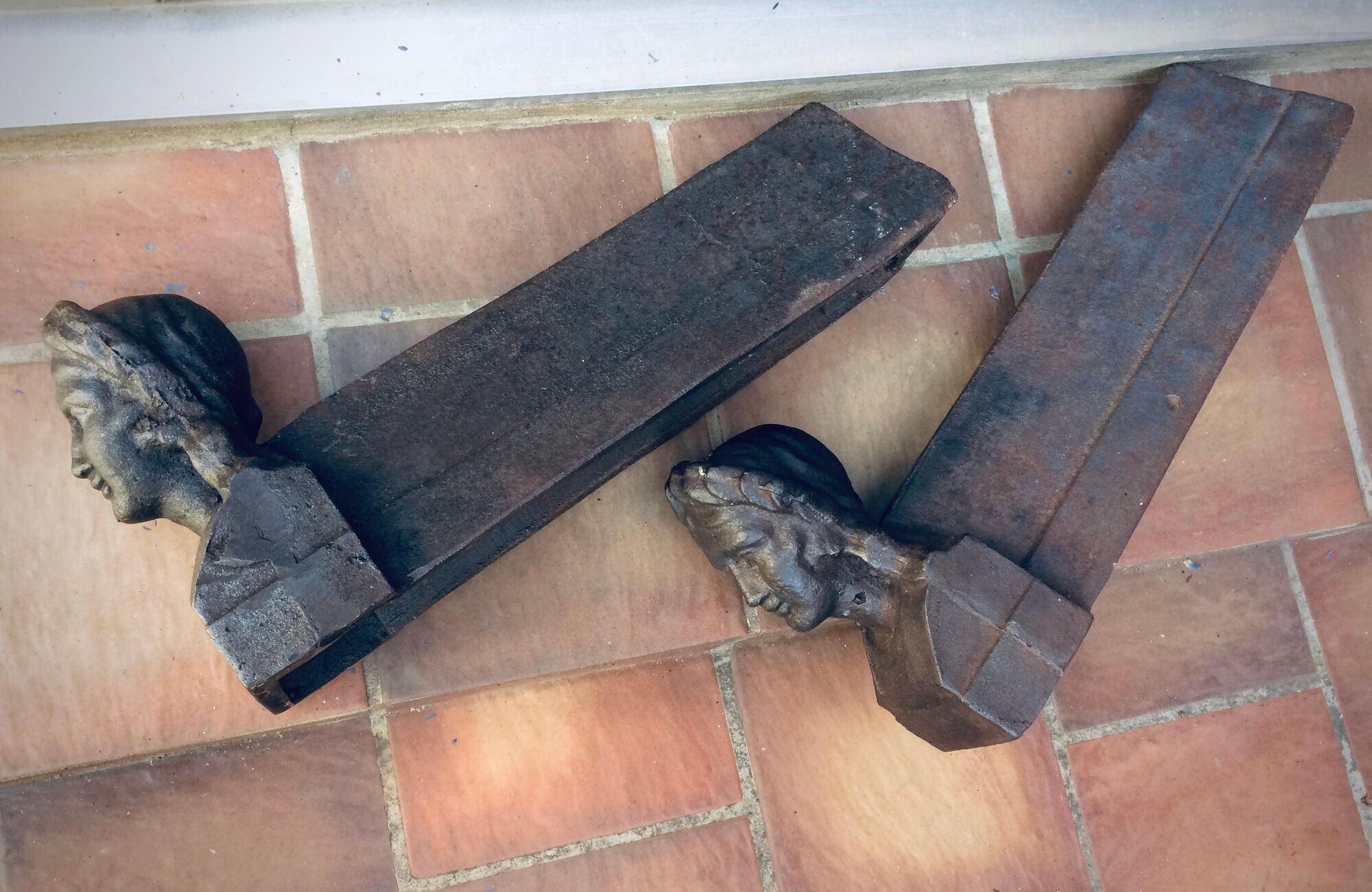 Pair of cast-iron chenet characters with laurels