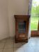 Small glass-fronted accent cabinet in cherry wood.