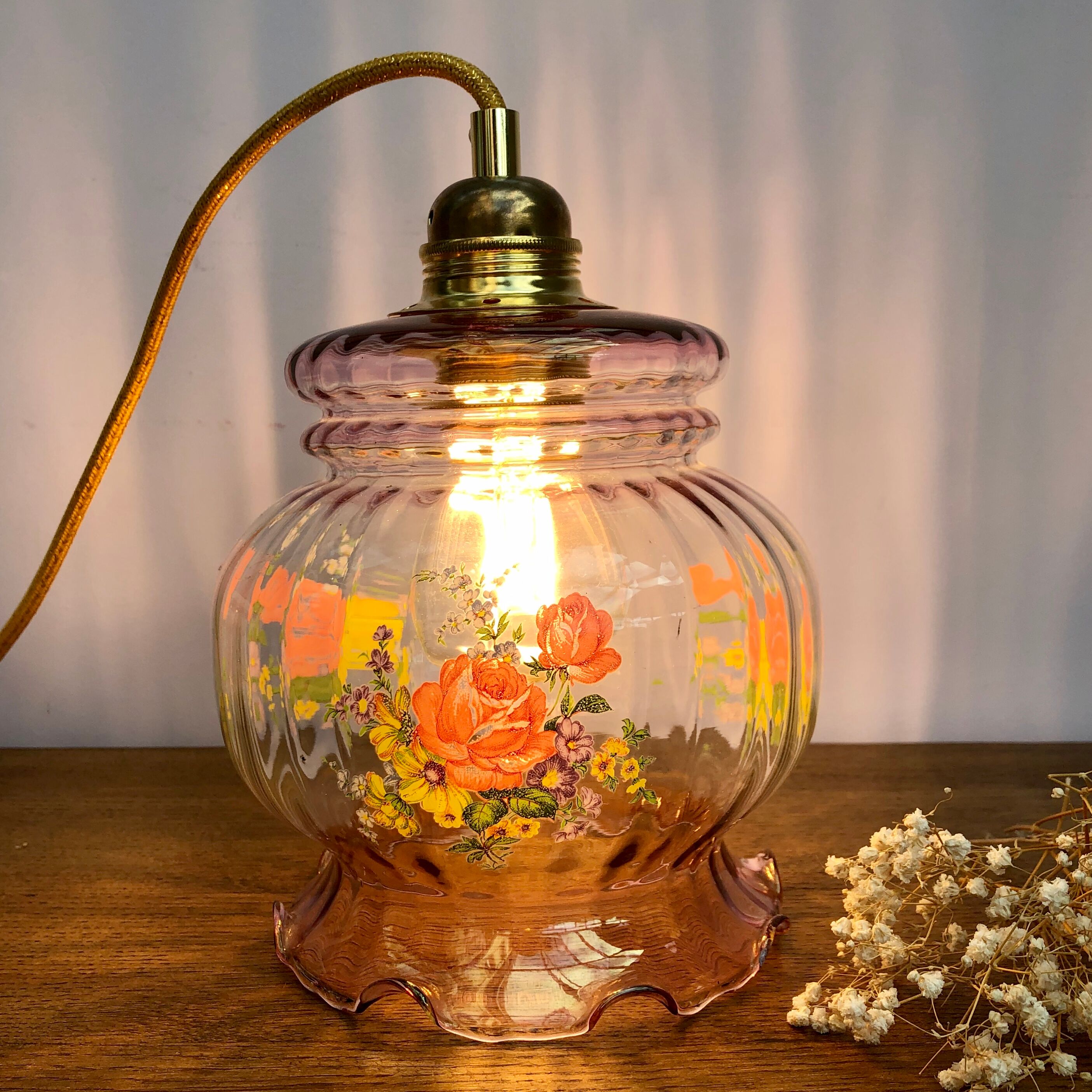 Vintage pink glass hand lamp with flower motifs