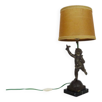 Old table lamp in repel, cherub, angel, cherub, putti with a bird in hand. 1930s
