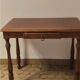 Table de style Louis-Philippe, en bois, avec tiroir et pieds tournés.