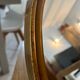 Old oval mirror in gilded wood from the 20th century