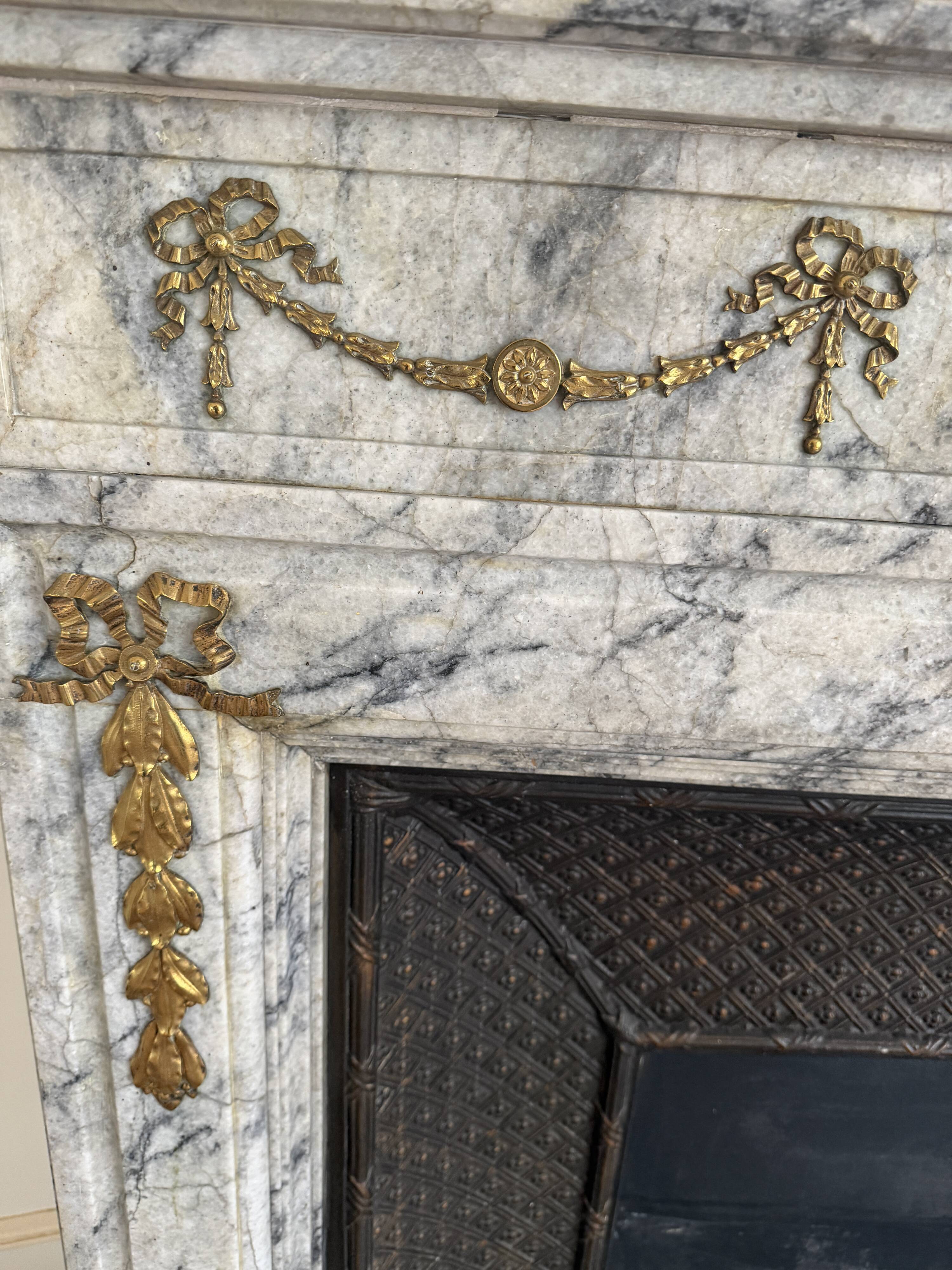 Louis XVI fireplace in veined grey marble with original gilded bronzes from the 19th century.
