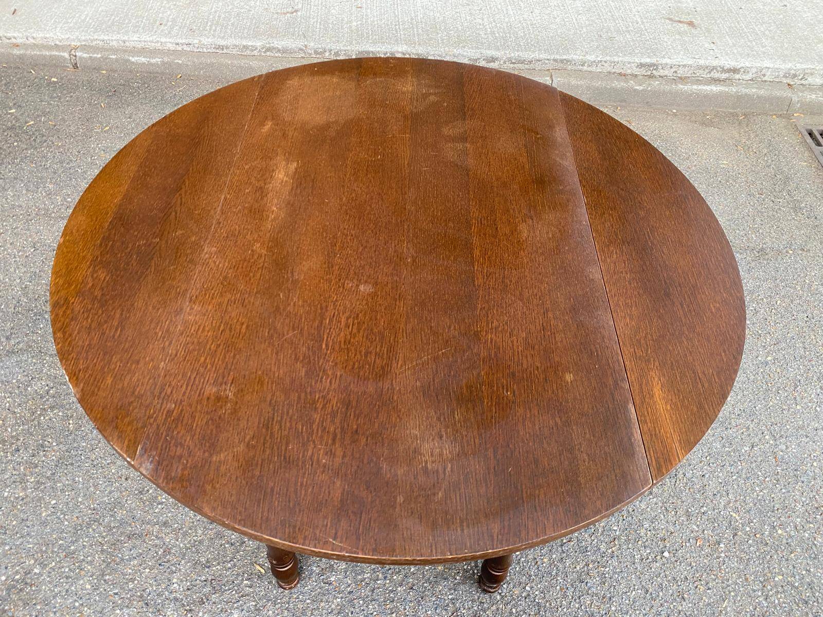 Round kitchen or dining table with extendable leaves in dark wood.