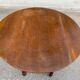 Round kitchen or dining table with extendable leaves in dark wood.