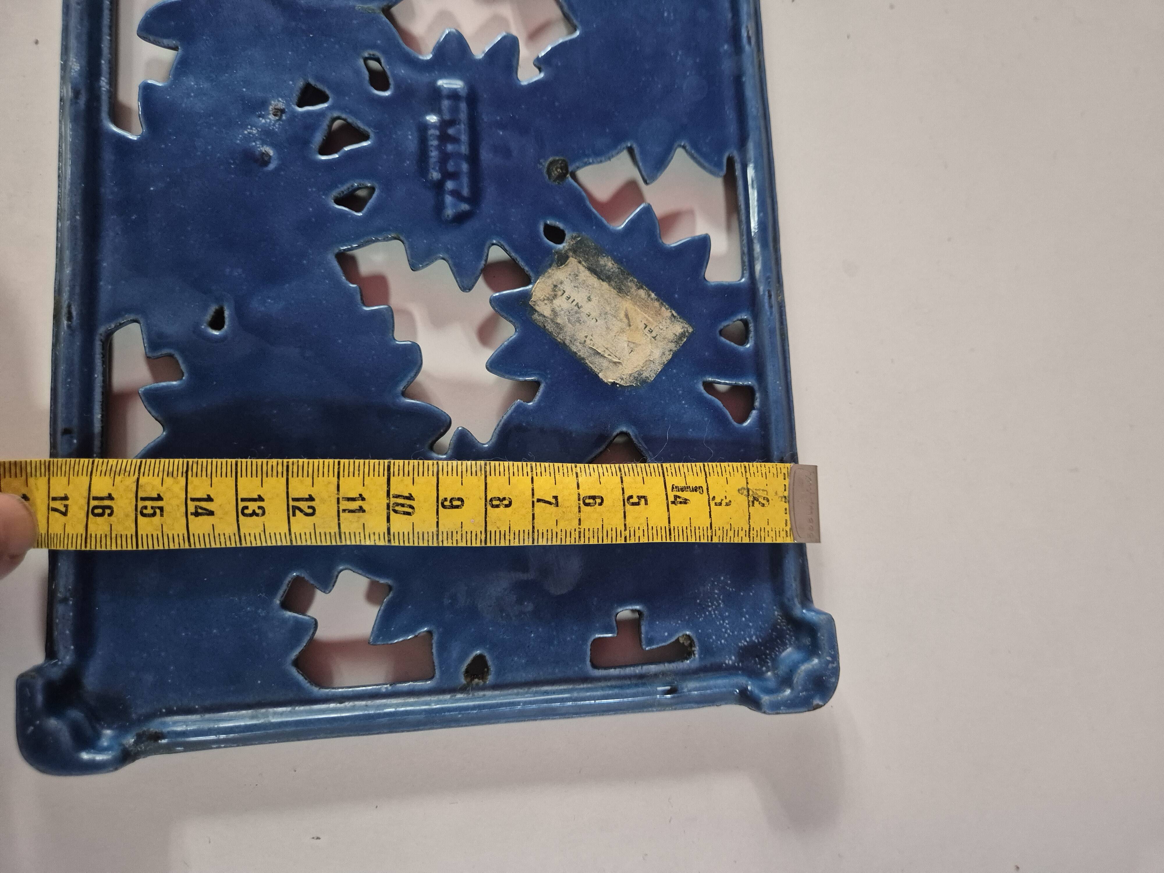Blue cast iron trivet with flowers, small chip in the paint otherwise very good.