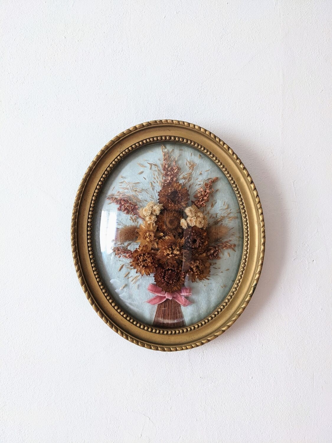 Golden vintage frame with bouquet of dried flowers under globe, wedding bouquet, antique bouquet