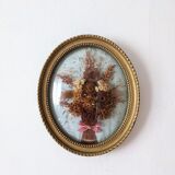 Golden vintage frame with bouquet of dried flowers under globe, wedding bouquet, antique bouquet