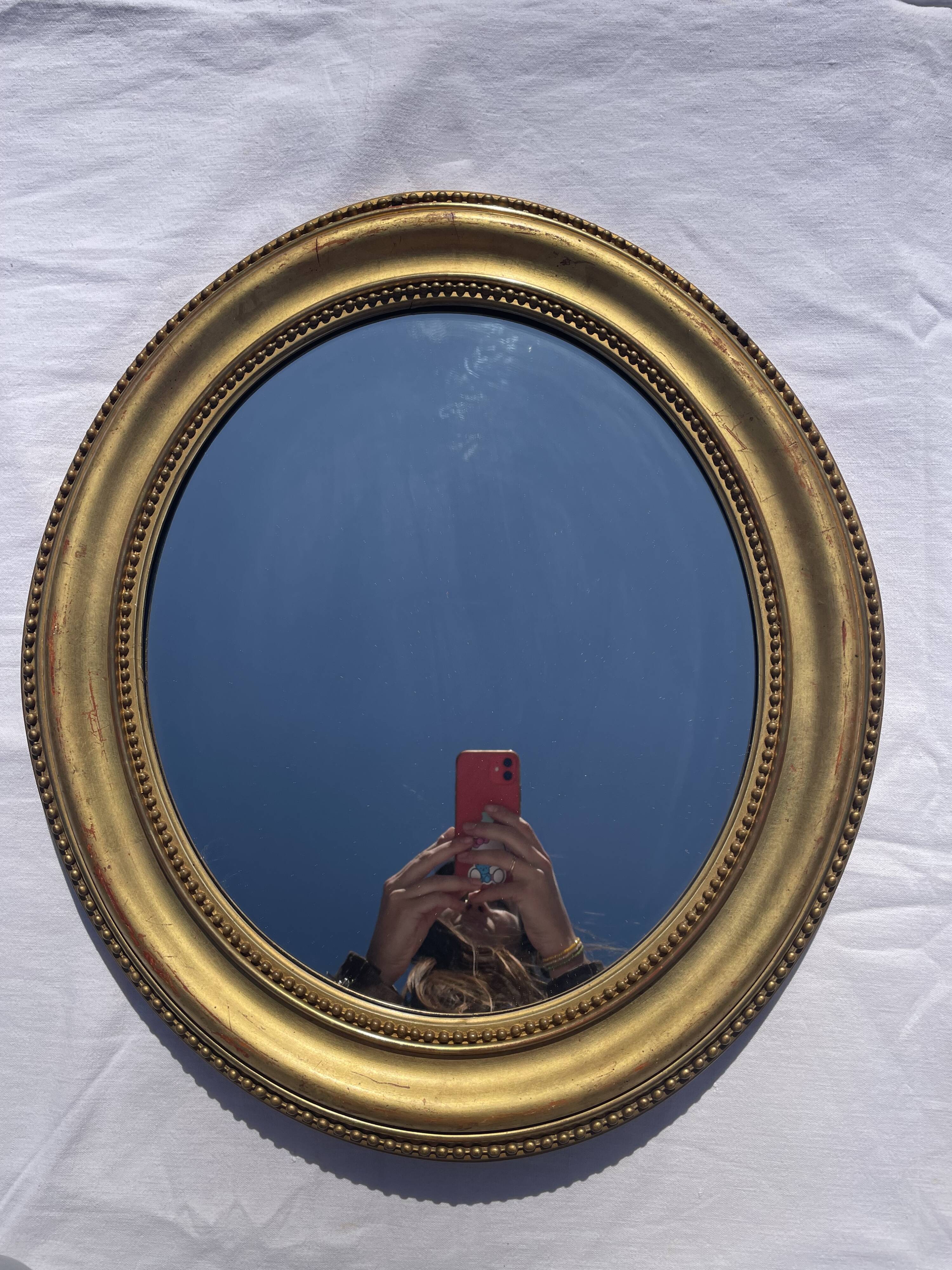 Duo de miroirs ovales et dorés en bois