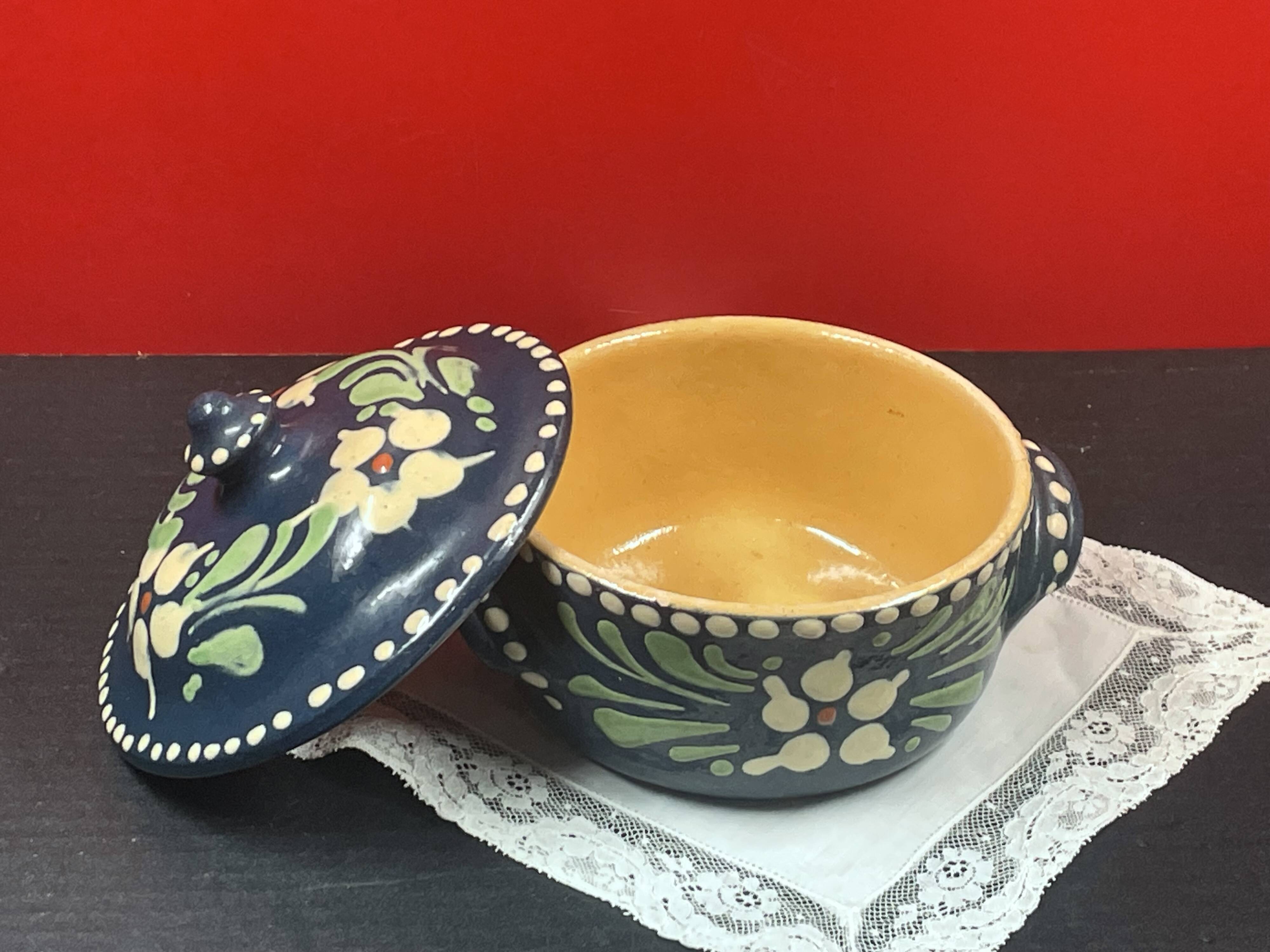 Small covered terracotta pot enamelled savoie or alsace flowers on a blue background