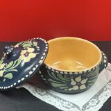Small covered terracotta pot enamelled savoie or alsace flowers on a blue background