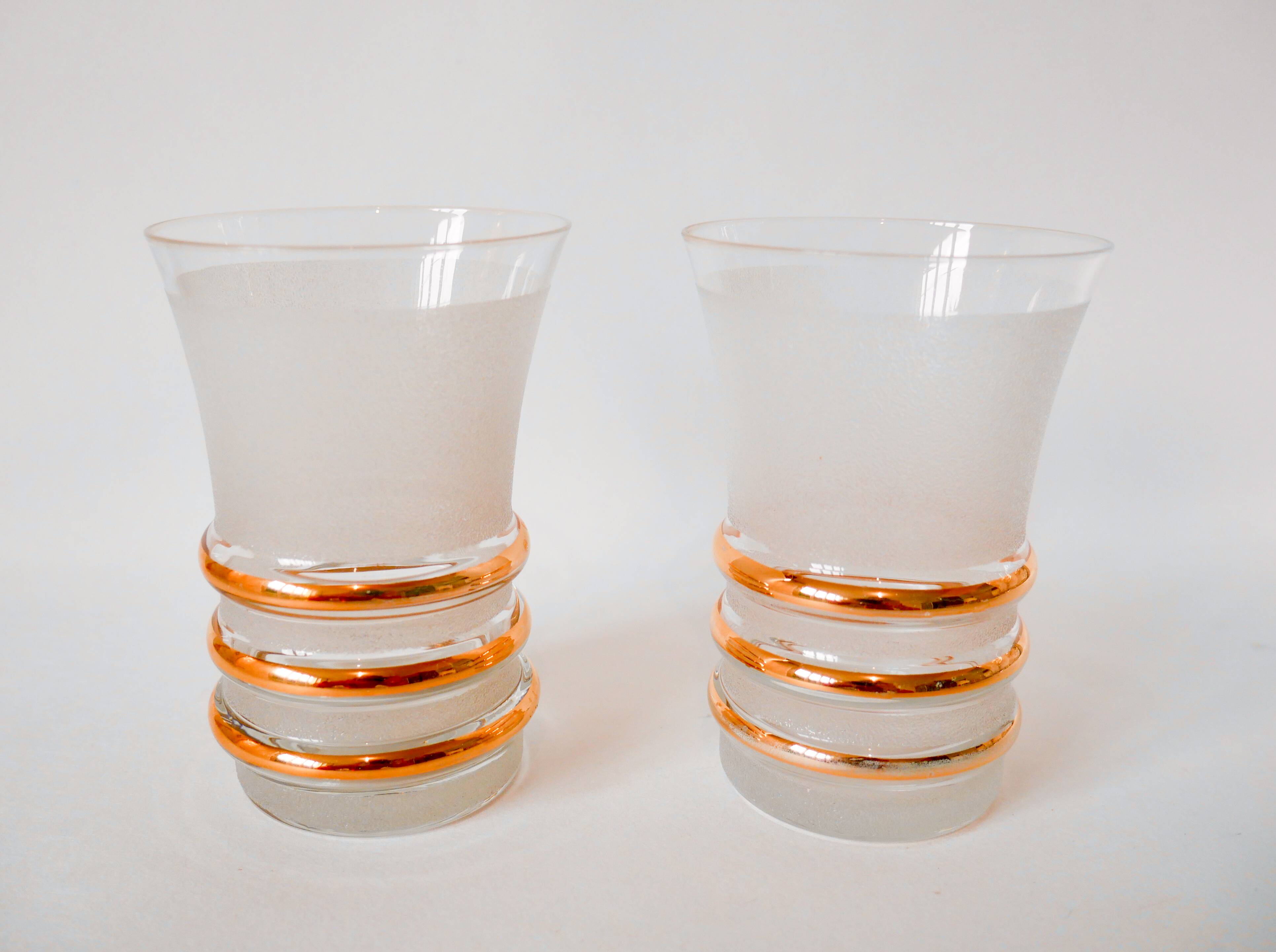 set composed of a pitcher and two large white granite glasses with gold edging from the 60s