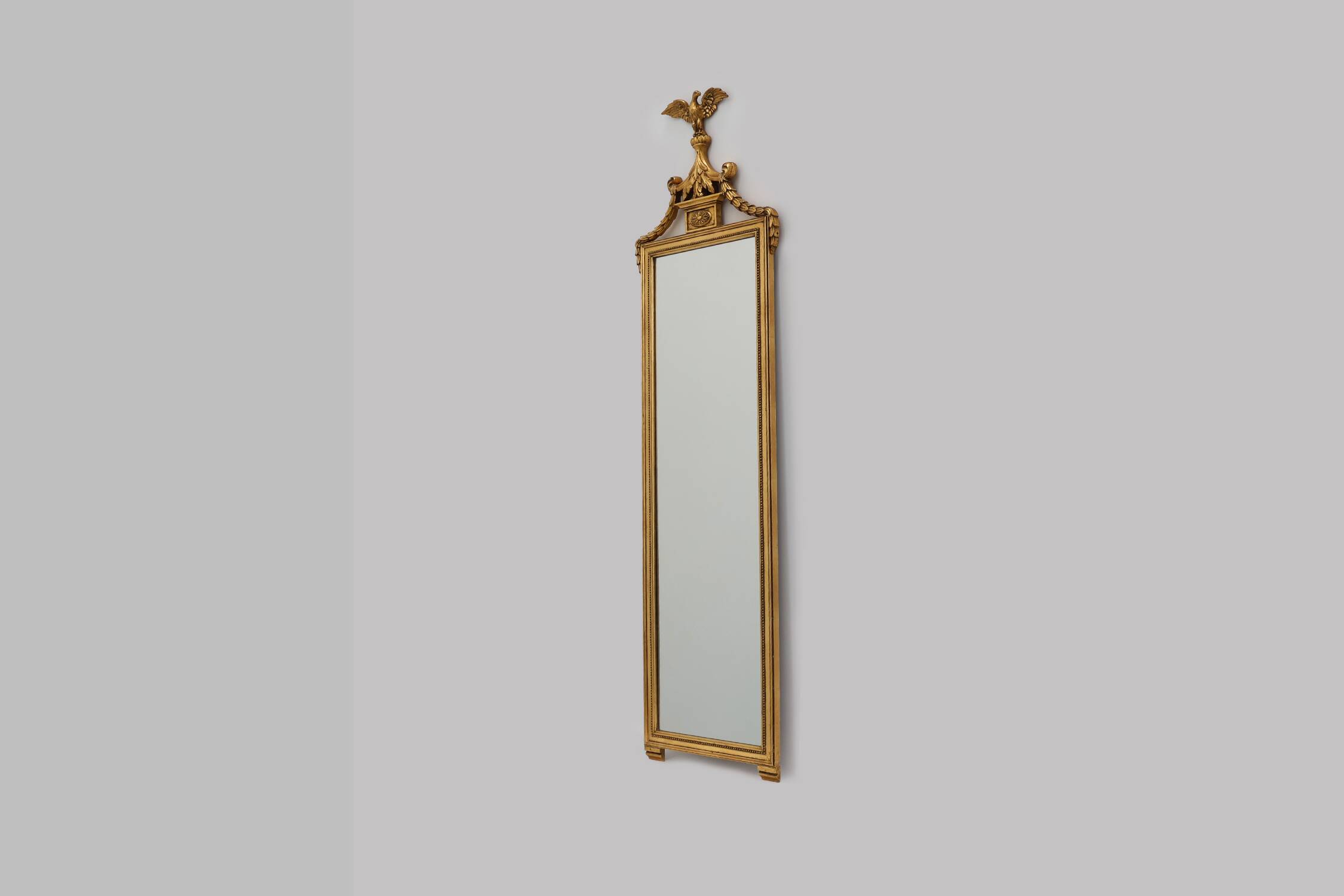 20th Century gilded wooden Empire style mirror with eagle on top