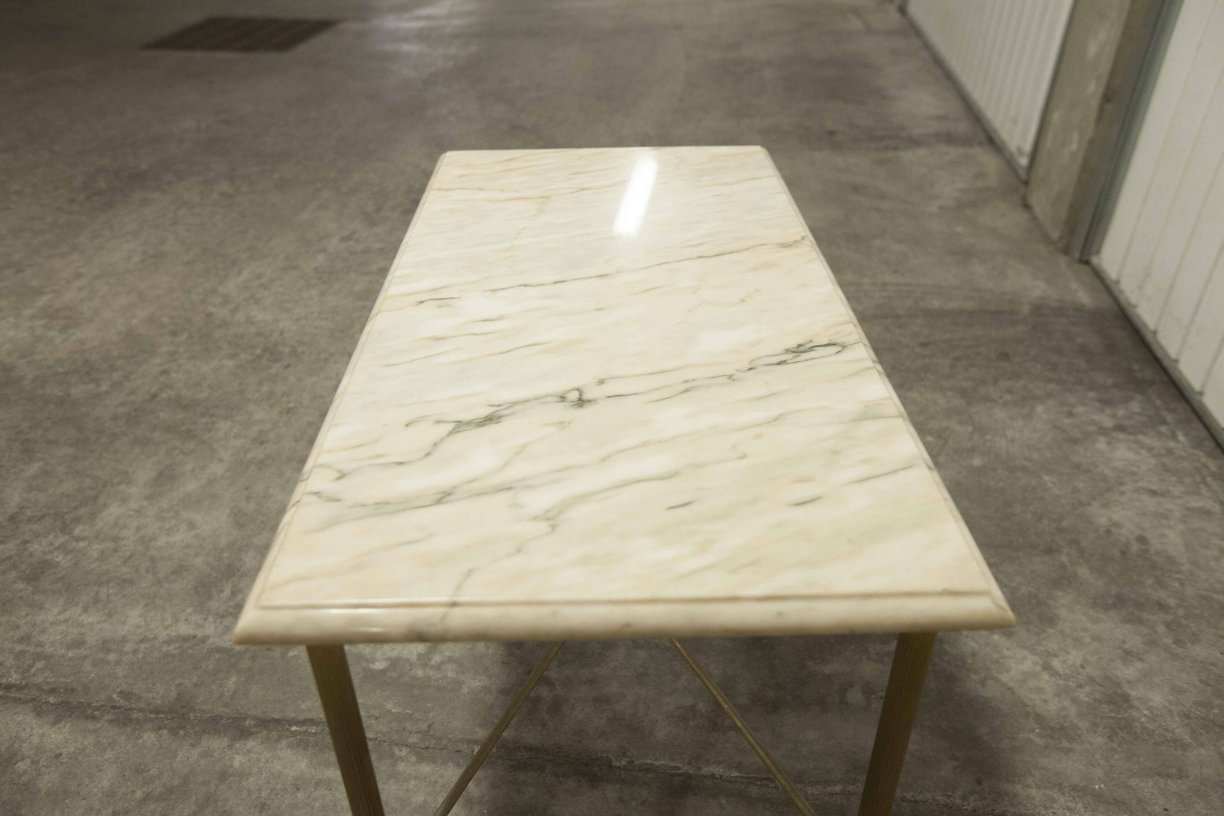 Marble coffee table with brass legs, height 46 cm.