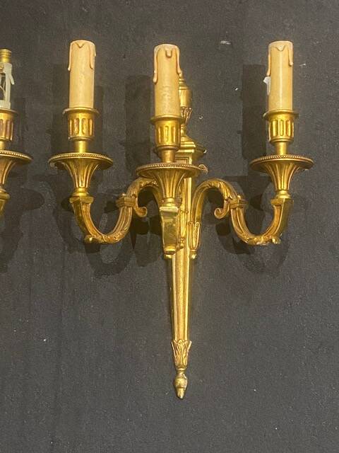 Pair of gilt bronze wall sconces with three lights in the Louis XVI style.