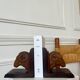 Pair of carved wooden bookends in the shape of ram's heads.