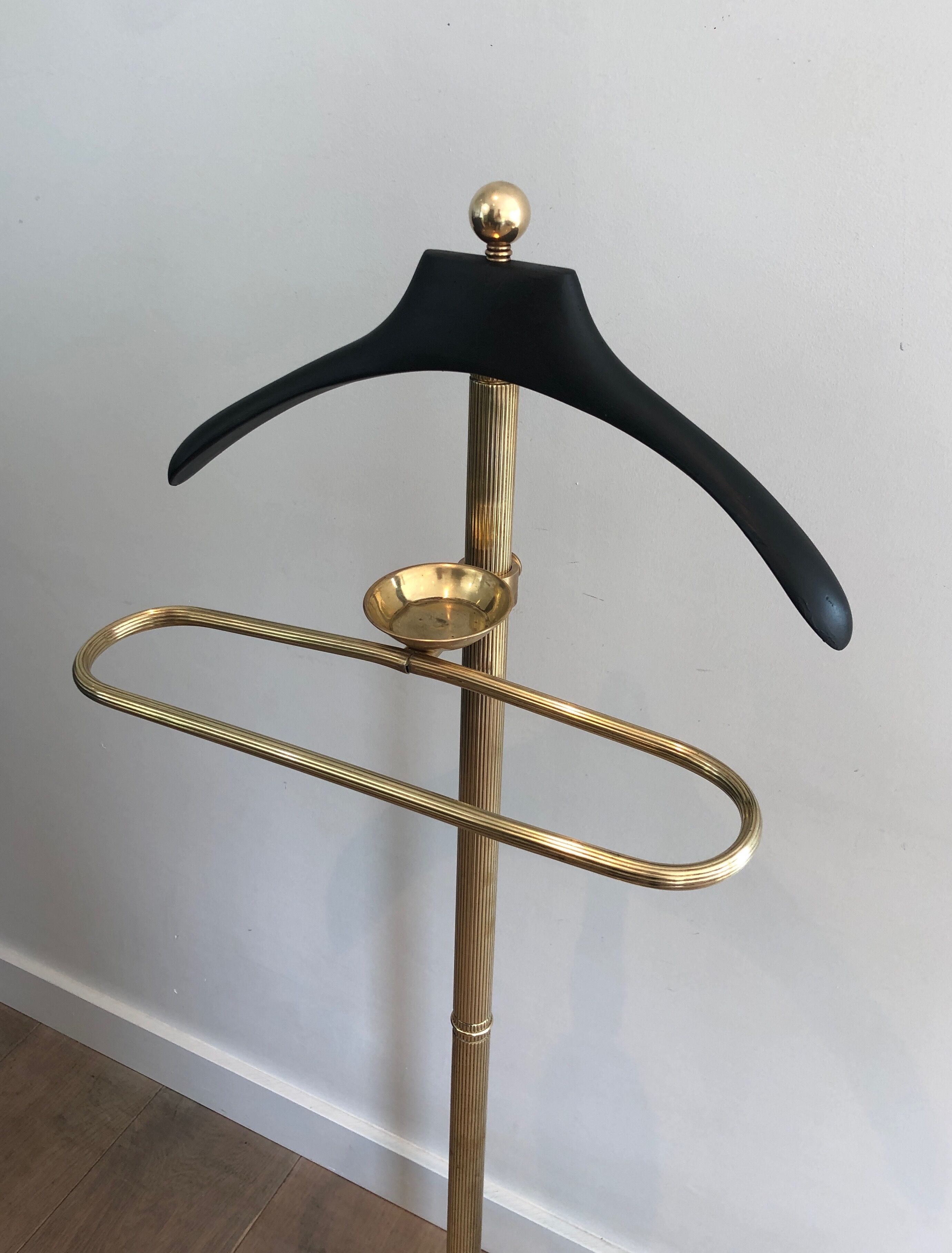 Neoclassical style valet stand in brass and black lacquered wood. French work. Circa 1940