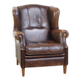 Wing chair made of sheepskin and neatly finished with black piping