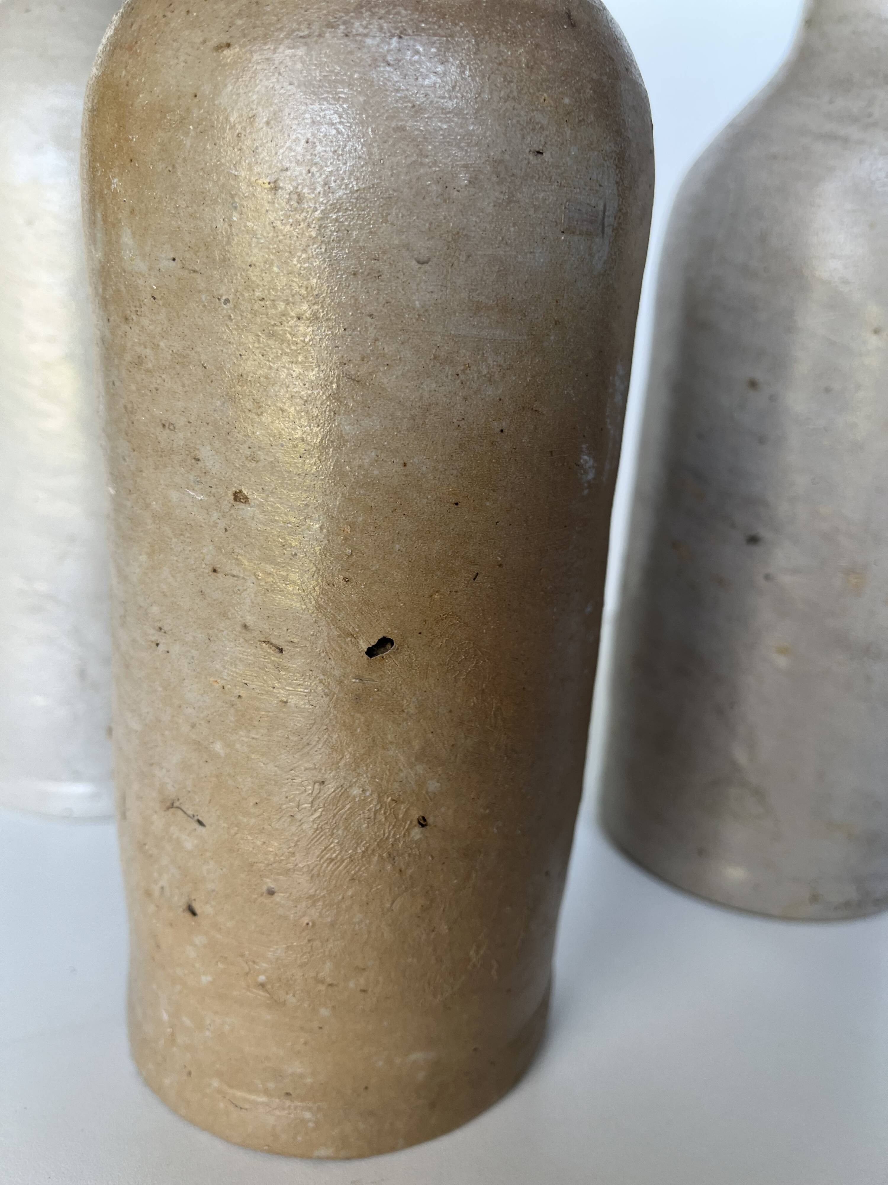 Trio of antique matte stoneware bottles