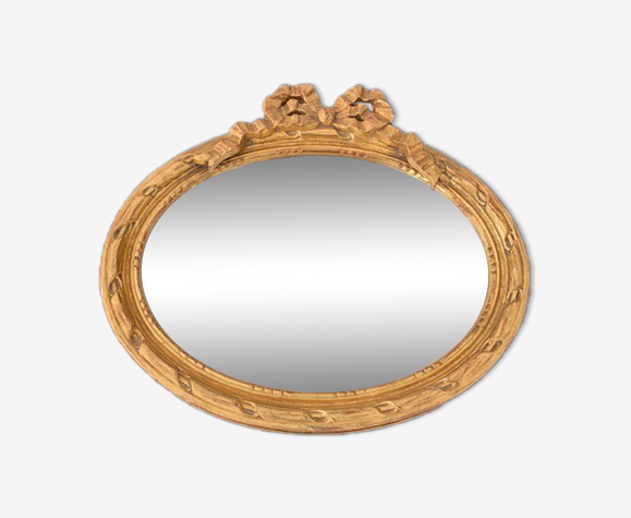 Miroir oval doré avec décor de noeud