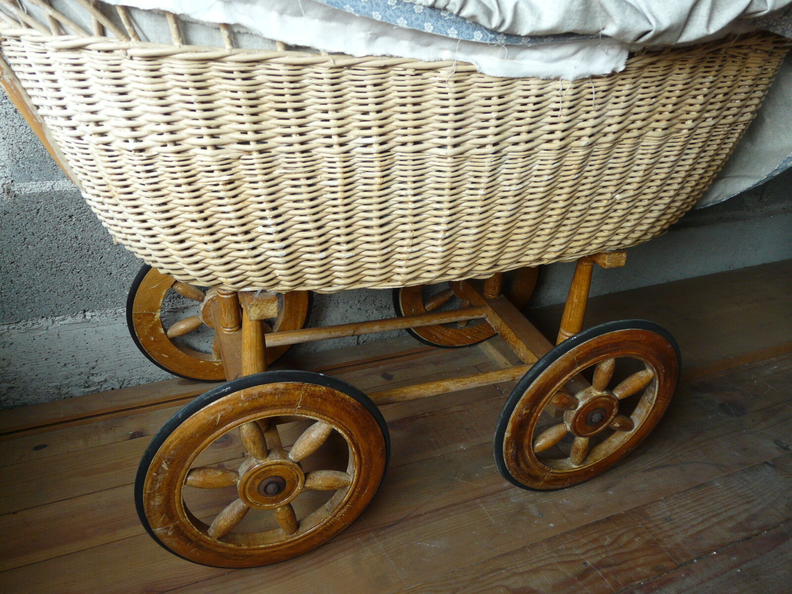 Old wooden cradle and wicker on wheels