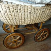 Old wooden cradle and wicker on wheels