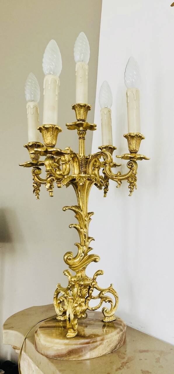 Massive gilded bronze chandeliers from the mid-20th century with marble bases.