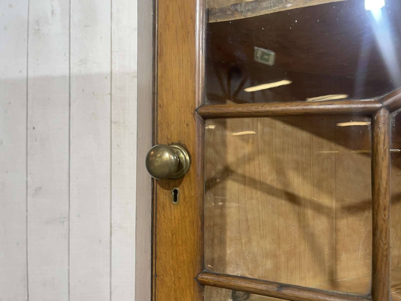 19th-century English corner cabinet in oak, mahogany, and fir.