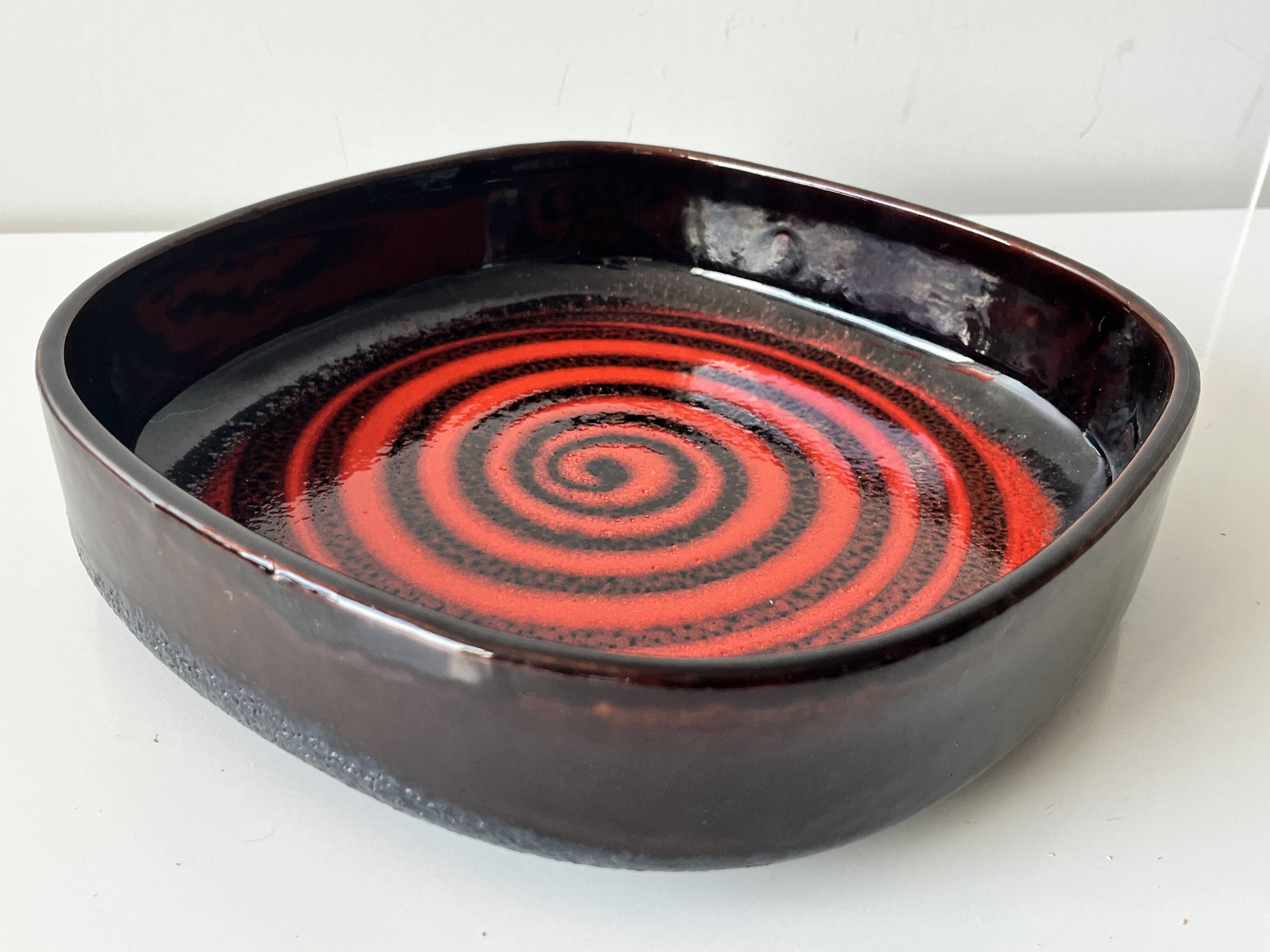 Large decorative ceramic catchall with red and black spiral pattern.