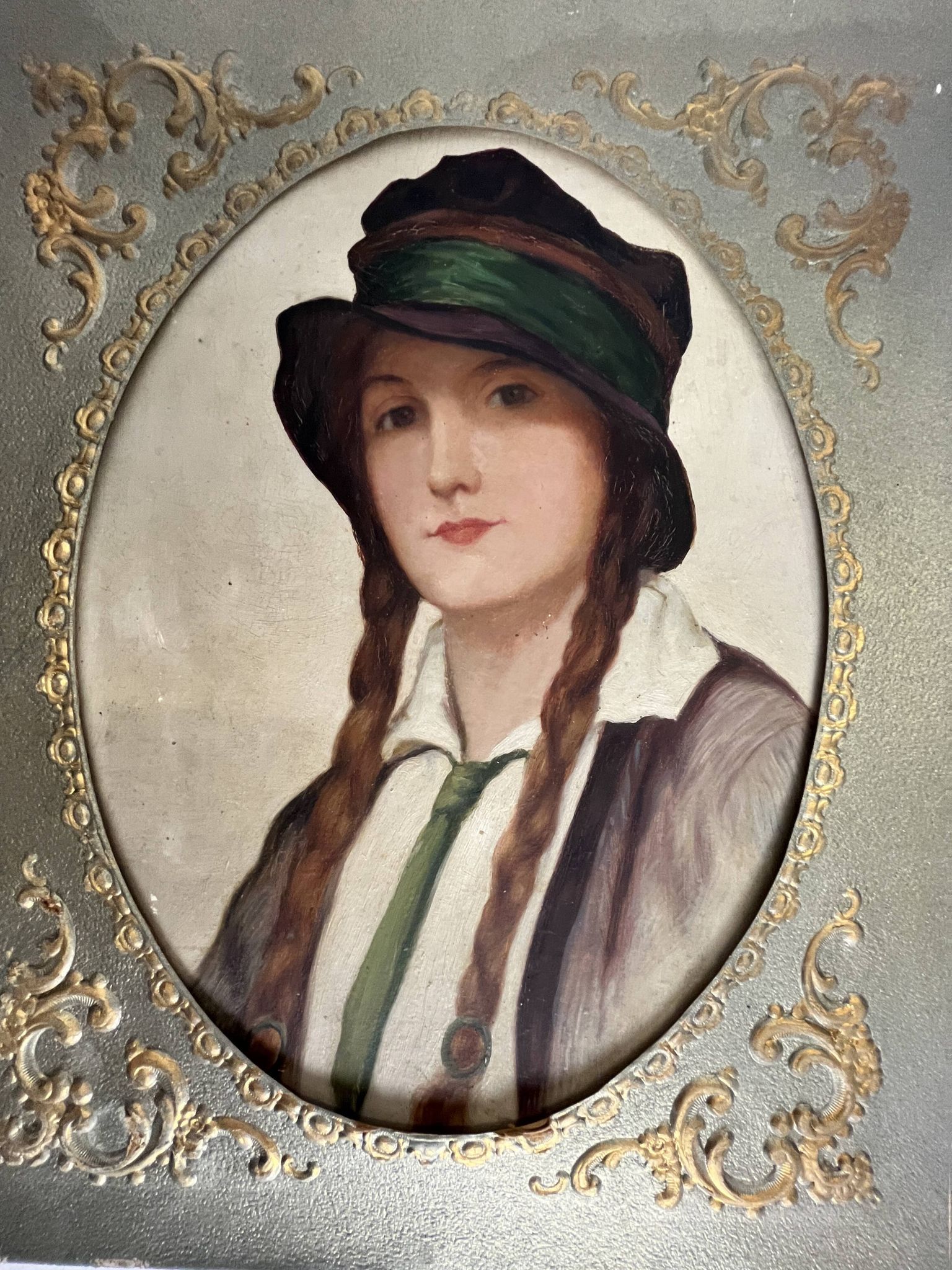 Old portrait of a young woman with braids and a hat, circa 1930